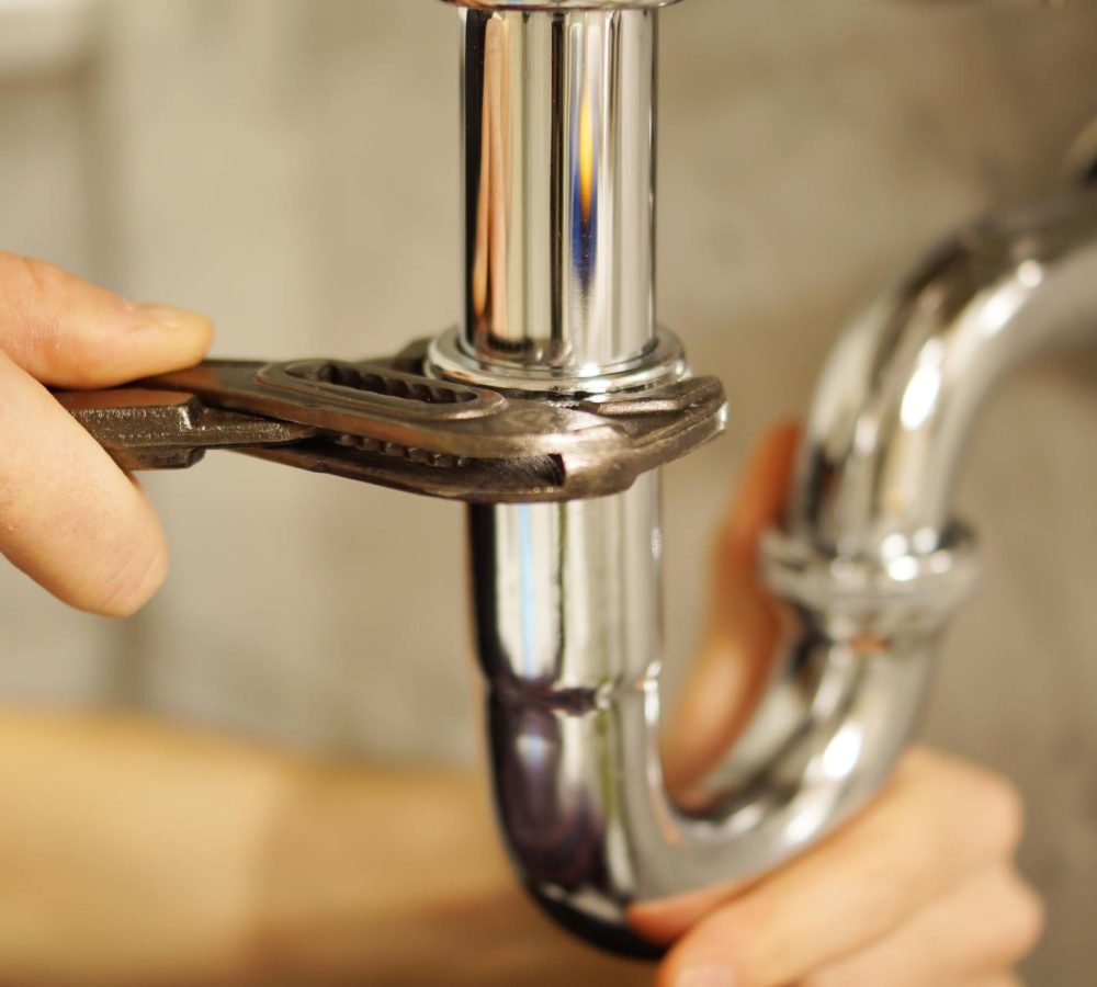 professional doing plumbing work on kitchen sink