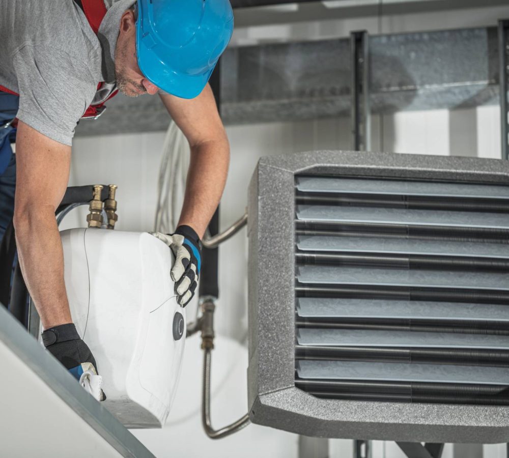 professional in blue work hat installing water heater